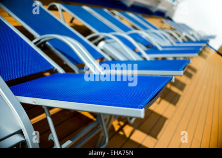 blaue Sonnenliegen aufgereiht auf deck Stockfoto