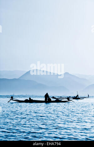 Menschen vor Ort in Booten, die Ernte Unkraut bei Sonnenaufgang, Inle-See, Myanmar (Burma), Asien Stockfoto