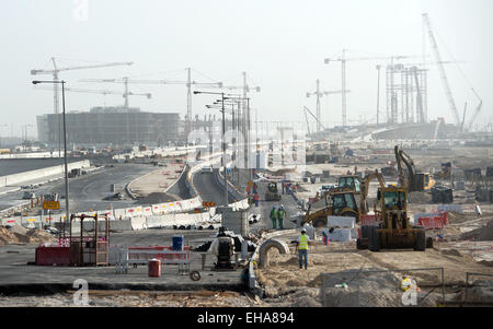 Doha, Katar. 10. März 2015. Ein Blick auf Bauherren und Baufahrzeugen bei der Arbeit auf einer Baustelle in Doha, Katar, 10. März 2015. Qata soll die 2022-Fußball-Welt zu beherbergen. Katar zog internationale Kritik bezüglich der Abstimmung auf die WM und in Bezug auf die Arbeitsbedingungen der ausländischen Bauarbeitern und Buiders. Foto: Bernd von Jutrczenka/Dpa/Alamy Live News Stockfoto