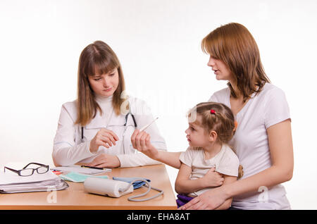 Frau mit einem kleinen Kind an der Rezeption bei der Kinderarzt Stockfoto