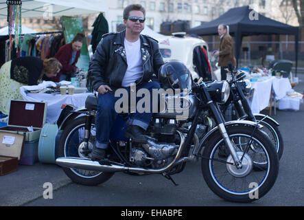 Vereinigtes Königreich, London: Ein Stall-Verkäufer wird fotografiert sitzen auf einem klassischen Motorrad auf dem Display an einem klassischen Flohmarkt in Southbank in London am 16. März 2014. Leute verkaufen Antiquitäten von der Rückseite der Oldtimers Stockfoto