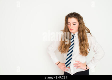 Gelangweilt satt launisch 13 14 15 Jahre alten Teenager Schulmädchen mit langen braunen Haaren UK Stockfoto