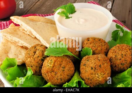 Falafel auf Blattsalat mit Pita-Brot und Tzatziki-Sauce-Nahaufnahme Stockfoto