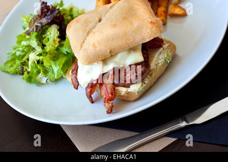 Hamburger mit Speck, Käse, Salat und Pommes frites Stockfoto