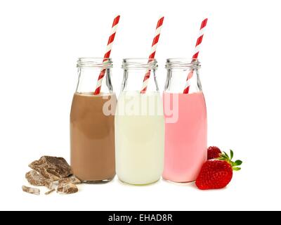 Verschiedene Varianten von Milch in Flaschen mit Schokolade und Erdbeeren isoliert auf weiss Stockfoto