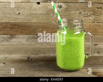 Gesunden grünen Smoothie in einem Einmachglas Becher auf altem Holz Stockfoto