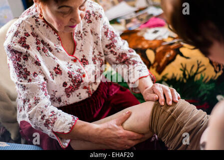 Milinchuk Halina, alternative Medizinpraktiker, heilen Krampfadern von ihrer Patientin, massieren und Rechtschreibung Duo-theistische heidnisch-christlichen Gebet, Koziatyn, Region Winnyzja, Ukraine Stockfoto