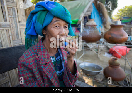 Burmesische Frau raucht eine Cheroot in ihrer Hütte am Strand Mingun in Mandalay, Myanmar Stockfoto