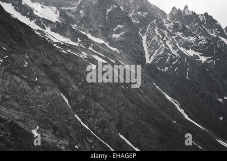 Grau, karge, schneereiche Winter Berglandschaft mit gewundenen Pfad im Nationalpark Ecrins, Französische Alpen. Stockfoto