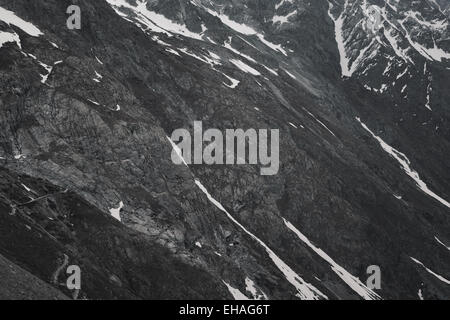 Grau, karge, schneereiche Winter Berglandschaft mit gewundenen Pfad im Nationalpark Ecrins, Französische Alpen. Stockfoto