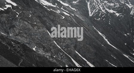 Grau, karge, schneereiche Winter Berglandschaft mit gewundenen Pfad im Nationalpark Ecrins, Französische Alpen. Stockfoto