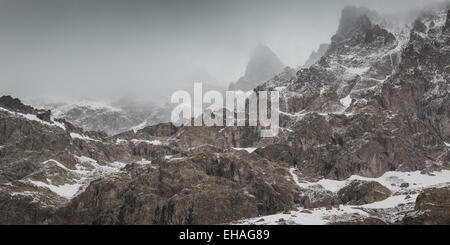 Zerklüftete Gipfel in dicke Wolke in einem Schneesturm auf der Südseite des Berges Barre des Ecrins, Französische Alpen. Stockfoto