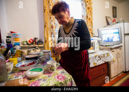 Milinchuk Halina, alternative Medizinpraktiker, Mittagessen in ihrem Zimmer nach Region Patienten Besuche, Koziatyn, Winnyzja, Ukraine vorbereiten. 2 März. Foto von Oleksandr Rupeta. Stockfoto