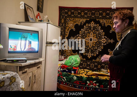 Milinchuk Halina, alternative Medizinpraktiker, ruht vor dem Fernseher in ihrem Zimmer nach Region Patienten Besuche, Koziatyn, Winnyzja, Ukraine. 2 März. Foto von Oleksandr Rupeta. Stockfoto