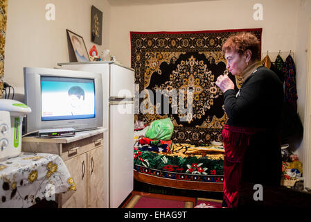 Milinchuk Halina, alternative Medizinpraktiker, ruht vor dem Fernseher in ihrem Zimmer nach Region Patienten Besuche, Koziatyn, Winnyzja, Ukraine. 2 März. Foto von Oleksandr Rupeta. Stockfoto