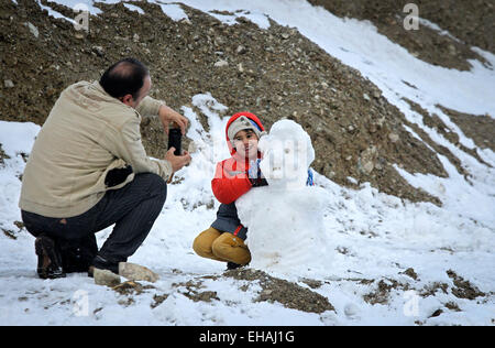 Teheran, Iran. 10. März 2015. Ein Mann fotografiert sein Kind und einen Schneemann in Nord-Teheran, der Hauptstadt des Iran, am 10. März 2015. Der erste Schnee im Jahr 2015 getroffen Teheran am Dienstag. © Ahmad Halabisaz/Xinhua/Alamy Live-Nachrichten Stockfoto