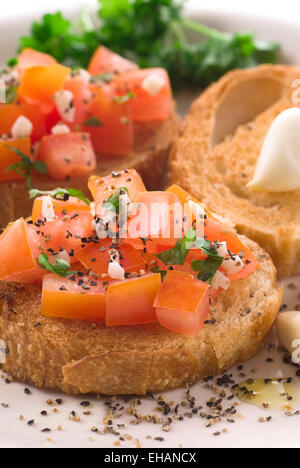 Bruschetta mit Tomaten, Olivenöl, Petersilie, Pfeffer und Knoblauch. Stockfoto