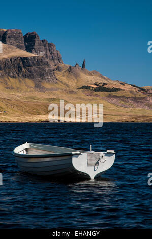 Die Storr und der Old Man of Storr unter einem tiefblauen Himmel mit einer kleinen weißen Ruderboot auf Loch Fada im Vordergrund. Insel Stockfoto