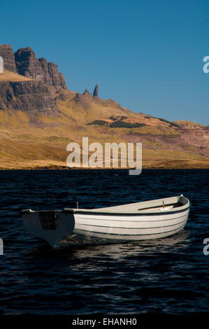 Die Storr und der Old Man of Storr unter einem tiefblauen Himmel mit einer kleinen weißen Ruderboot auf Loch Fada im Vordergrund. Insel Stockfoto