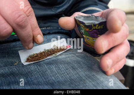 Ein Mann, der einen Joint mit Happy Joker, Legal High Stockfoto