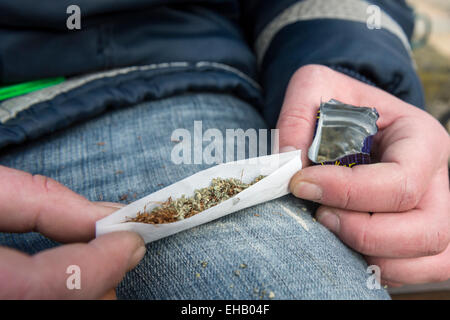 Ein Mann, der einen Joint mit Happy Joker, Legal High Stockfoto