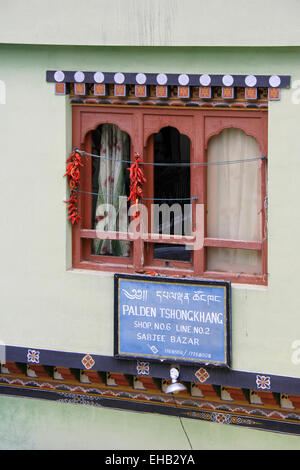 Girlanden aus Paprika werden in einem Fenster in Thimphu, Bhutan, an 7. Oktober 2011 aufgehängt. Stockfoto