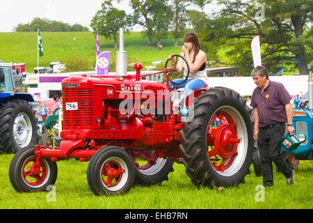 Junge Frau auf klassische Traktor McCormick Farmall BM. Skelton Show Cumbria, England, UK. Stockfoto