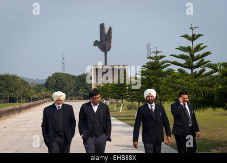 Indische Anwälte oder Juristen in der Nähe von Le Corbusiers offene Hand-Symbol in der Nähe der High Court in Chandigarh, Indien. Stockfoto