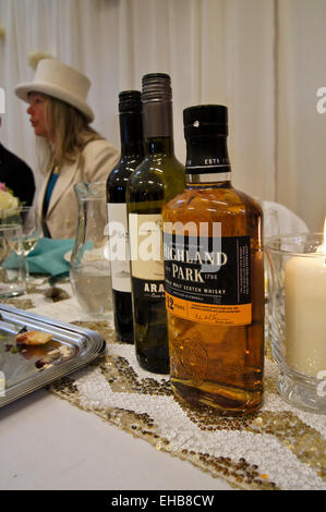 Eine Flasche "Highland Park" single Malt Scotch Whisky, mit Flaschen Wein und Frau in weißen Hut auf einer Hochzeit Frühstück Stockfoto