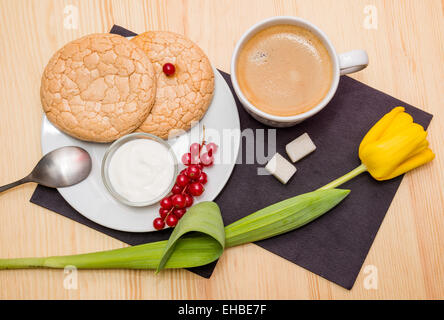 Still-Leben: eine Tasse Kaffee und Gebäck auf Platte auf Holztisch Stockfoto