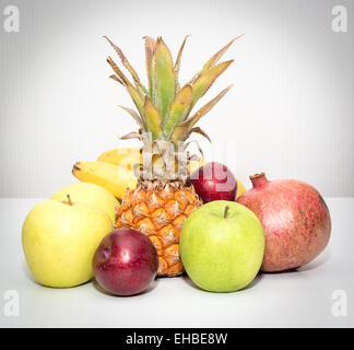 Stillleben mit Früchten Ananas, Äpfel, Bananen, Pflaumen, Granatapfel Stockfoto