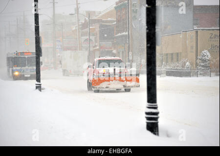 Eine Pick up Truck mit Schneepflug angeschlossen Laufwerke auf einer verschneiten Straße in Ontario, Kanada. Stockfoto