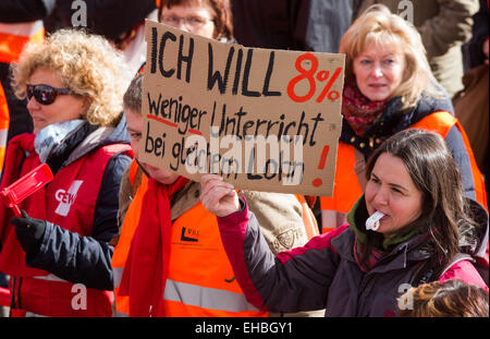 Schwerin, Deutschland. 11. März 2015. Ein Demonstrator trägt ein Zeichen, das liest "Ich wan 8 Prozent weniger Unterrichtsstunden auf dem gleichen Lohn", wie sie mit Tausenden von Mitarbeitern der Beschäftigten im öffentlichen Dienst in einer gemeinsamen Kundgebung des deutschen Lehrers Union "GEW", united-Dienste Dienstleistungsgewerkschaft "Ver.di" und der Gewerkschaft der Polizei "BIP" in Schwerin, Deutschland, 11. März 2015 teilnimmt. Die Gewerkschaften fordern eine 5,5 Prozent und mindestens 175 Euro pro Monat Lohnerhöhung für die Beschäftigten im öffentlichen Dienst. Foto: Jens Büttner/Dpa/Alamy Live News Stockfoto