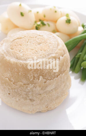 Steak und Niere Pudding serviert eine traditionelle gedämpfte Talg Konditorei Torte mit neuen Kartoffeln und grünen Bohnen Stockfoto