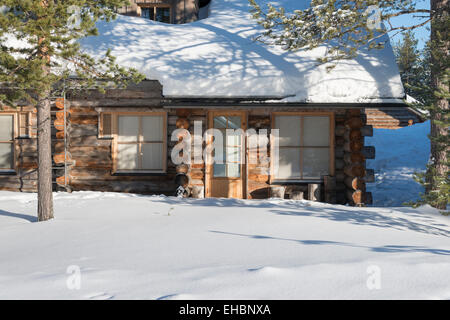 Ein Blockhaus in Levi Lapland Finnland mit Schnee und Sonnenschein.  Als Winter-Ferienunterkunft verwendet. Stockfoto