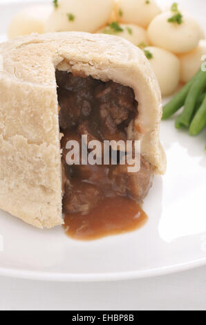 Steak und Niere Pudding serviert eine traditionelle gedämpfte Talg Konditorei Torte mit neuen Kartoffeln und grünen Bohnen Stockfoto