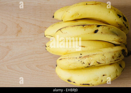 Reife Bündel Bananen auf hölzernen Hintergrund Stockfoto