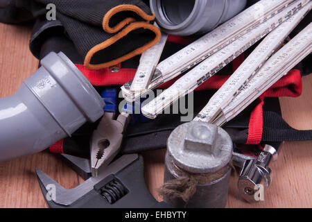 Professionelle Sanitär-Werkzeuge und Dichtungen am Arbeitsplatz gelegt. Stockfoto