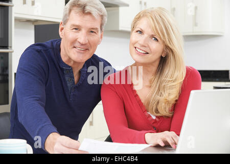 Älteres Paar, die Überprüfung der nationalen Finanzen lächelnd Stockfoto