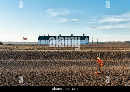 Eine Reihe alter Cottages der Küstenwache im abgelegenen Küstenort Shingle Street, Suffolk, Großbritannien. Ein Kommunikationsturm der Küstenwache befindet sich auf der rechten Seite Stockfoto