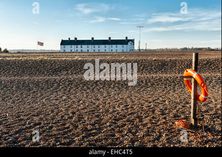 Eine Reihe alter Cottages der Küstenwache im abgelegenen Küstenort Shingle Street, Suffolk, Großbritannien. Ein Kommunikationsturm der Küstenwache befindet sich auf der rechten Seite Stockfoto
