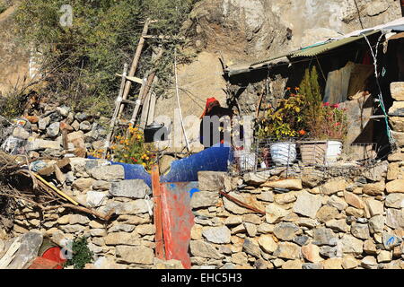 DREPUNG, TIBET, CHINA - 19. Oktober: Tibetisch-buddhistische Nonne bereitet Tee in eine metallische Teekanne-außerhalb von ihrer Hütte in dem Drepung Mo Stockfoto