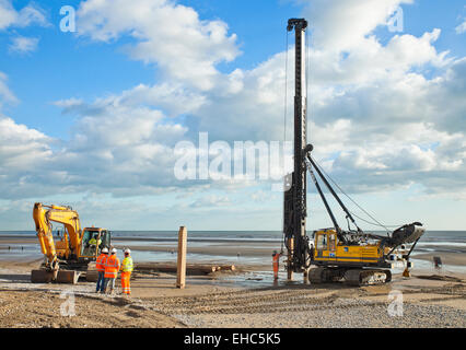 Ramme bei der Arbeit, Holz Buhnen in Camber Sands fahren. Stockfoto