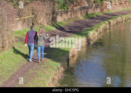 Junges Paar kaukasischen unterhielten entlang Stourbridge Canal Leinpfad, Staffordshire, England, UK im Winter Stockfoto