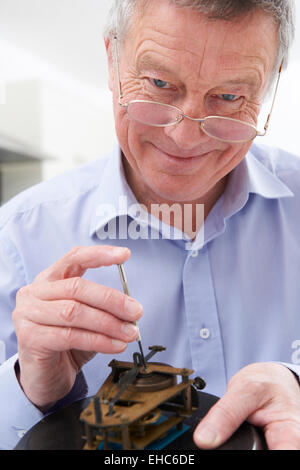 Senior woman ausbessern Uhrwerk Stockfoto