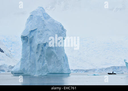 Antarktis Eisberg, Eisberg, schwebt in der Antarktis-Landschaft aus Eis mit Zodiac-Fahrer. Stockfoto