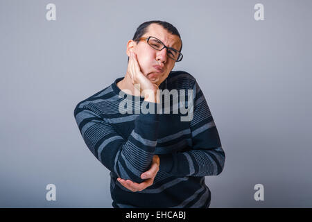 Männchen der Europäischen Erscheinungsbild Brunet in einem gestreiften Pullover legte seine Stockfoto