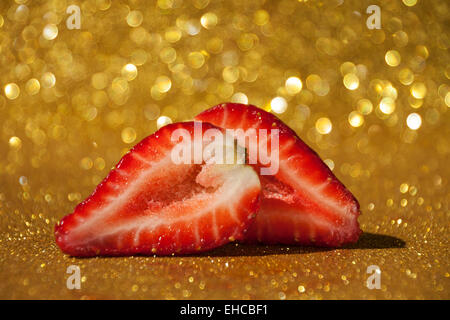 Offenen Erdbeere auf gold glitzernden Hintergrund voller Bokeh. Stockfoto