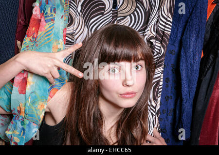 Teenager-Mädchen mit ihrer Garderobe zeigt eine Schere mit einer hand Stockfoto