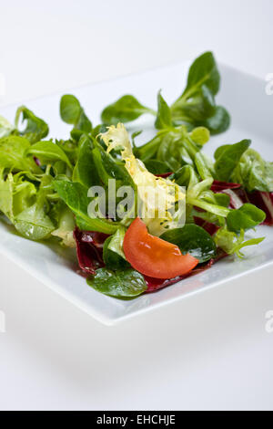 Detail von gemischtem Salat auf einem weißen Teller Stockfoto